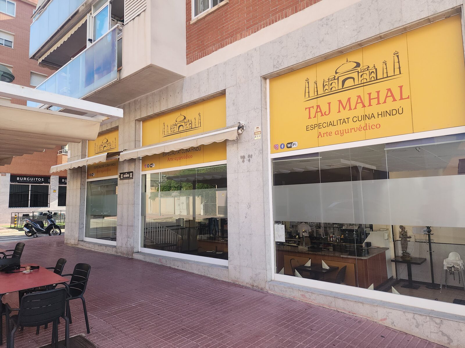 Fachada del restaurante Taj Mahal en Tarragona con su rótulo amarillo y terraza