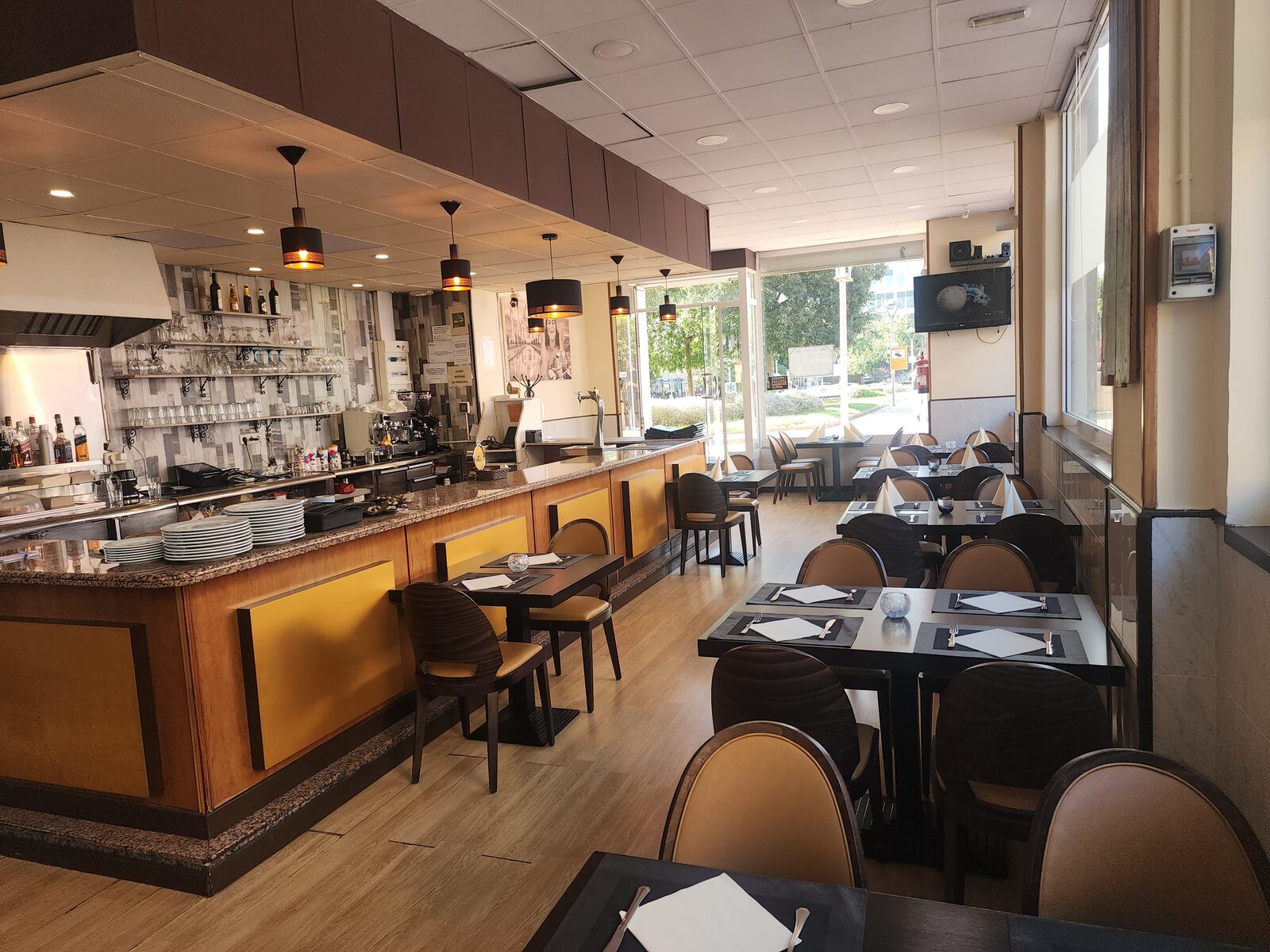 Comedor del restaurante con la barra al fondo, preparado para grupos